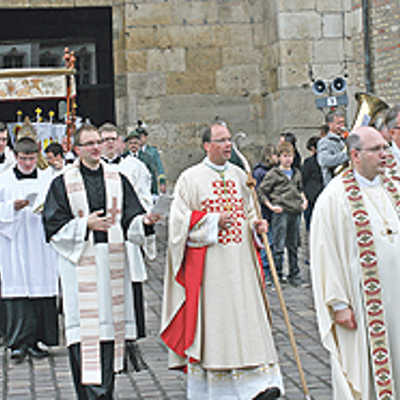 Die Fronleichnamsprozession mit Bischof Dr. Stephan Ackermann (Mitte) setzt sich vor dem Dom in Bewegung.