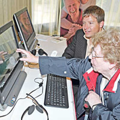 Eine Seniorin erprobt mit Unterstützung von Sebastian Weber (IESE-Frauenhofer Institut) einen rechnergestützten Bewegungsmelder.