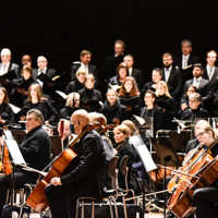 Orchester mit Chor im Hintergrund