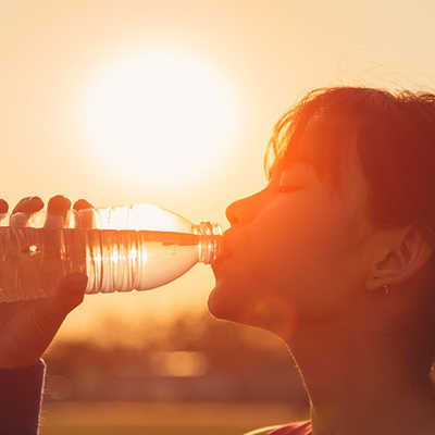 Eine Frau trinkt Wasser aus einer Flasche, 