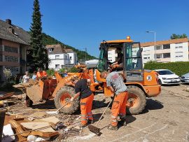 Mitarbeiterinnen und Mitarbeiter des Amtes StadtRaum räumen große Mengen an Dreck und Sperrmüll aus dem überschwemmten Stadtteil Trier-Ehrang weg.