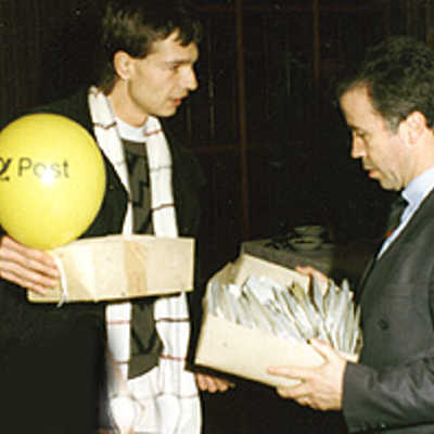 Der Weimarer Andreas Kossmann (links) überreicht OB Helmut Schröer ein Paket mit rund 2 000 Briefen, in denen Weimarer an ihre Partnerstadt Trier Einladungen und Kontaktwünsche aussprechen (1990).