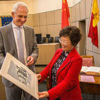 OB Wolfram Leibe überreicht der stellvertretenden Bürgermeisterin von Xiamen, Guo Guirong, eine Grafik der Porta Nigra.
