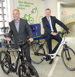 Foto: OB Klaus Jensen und SWT-Vorstand Dr. Olaf Hornfeck werben für die neue E-Bike-Ladestation im City-Parkhaus.