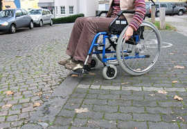 Foto: Rollstuhlfahrer an einer Bordsteinkante