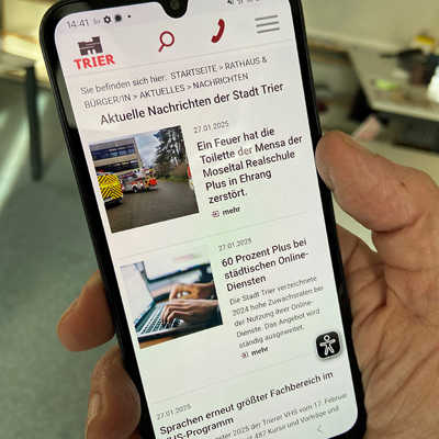 Eine Hand hält ein Smartphone mit Nachrichten auf dem Display 
