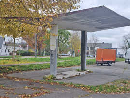 Die charakteristische Dachkonstruktion erinnert daran, dass hier früher eine Tankstelle war: Teilansicht des brach liegenden Gewerbegrundstücks an der Straßburger Allee.