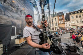 Die Band Rokken tritt auf einer Bühne des Altstadtfestes auf. Der Gitarrist hält seine E-Gitarre in die Kamera, dabei hat er seinen Mund weit aufgerissen.