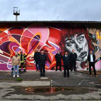 Graffiti-Künstler Karl Berg (r.) zeigt Dezernent Thomas Schmitt (l.), Ortsvorsteher Hans-Alwin Schmitz (2. v. l.), OB Wolfram Leibe (4. v. l.), Projektleiter Alexander Fisch (2. v. r.) und Vertretern der Feuerwehren die Graffitis auf dem ehemaligen Kasernengelände, bevor die meisten Gebäude abgerissen werden.