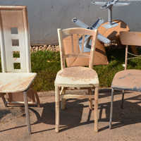 Stühle in verschiedenem Design stehen als Sperrmüll auf einer Straße in Ehrang.