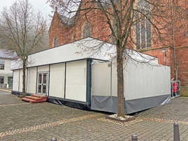 Der Pavillon für die Unterstützungs- und Begegnungsstätte steht vor der Kirche St. Peter in Ehrang