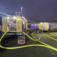 Zwei Feuerwehrwagen und zahlreiche Schläuche auf dem Gelände einer ehemaligen Fabrik in Trier-Biewer.
