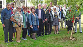 Mayor Colin Organ (Mitte mit Amtskette) und rechts neben ihm Rosemarie Berens (Gloucester-Metz-Trier-Gesellschaft) freuen sich mit den weiteren Gästen der Feier über den frisch gepflanzten Baum