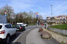 Blick von der Olewiger Straße in Richtung Kreisel an den Kaiserthermen, ein Mann steht auf einer Leiter und bringt das Schild ‚Grünpfeil‘ an der Ampel an.
