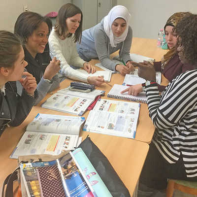 Teilnehmerinnen eines früheren Sprachkurses des Trierer Migrationsbeirats arbeiten gemeinsam an der Lösung einer Aufgabe aus ihrem Lehrbuch. Foto: Beirat für Migration und Integration