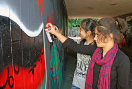 In einer Unterführung in Trier-Süd legen Basira und Masume (v. l.) letzte Hand an ihr Graffiti.