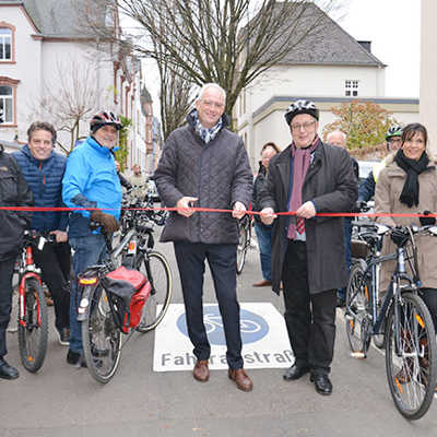 Flankiert von Mitgliedern des kommunalpolitischen Arbeitskreises Radverkehr durchschneiden Wolfram Leibe und Andreas Ludwig das Band zur Freigabe der ersten Trierer Fahrradstraße.
