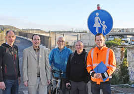 Thilo Becker, Marc Borkam, Bernd Hügle, Thomas Köllner und Julian Lehnart stehen vor einem Brückenaufgang und einem Verkehrsschild für einen Fußgängerweg.