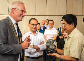 Oberbürgermeister Wolfram Leibe (l.) überreicht Minister Song Dahan (r.) im Beisein von Bundesjustizminister Heiko Maas als Gastgeschenk eine Büste von Karl Marx.