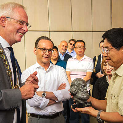 Oberbürgermeister Wolfram Leibe (l.) überreicht Minister Song Dahan (r.) im Beisein von Bundesjustizminister Heiko Maas als Gastgeschenk eine Büste von Karl Marx.