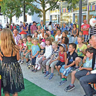 Zahlreiche Kinder und Eltern verfolgen gespannt die Tricks eines Zauberers und seiner Assistentin im SWT-Zirkus auf dem Kornmarkt.