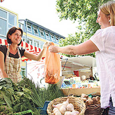 Marktbeschickerin Marina Adami im Gespräch mit einer Kundin, die auf dem Markt am Augustinerhof frisches Gmüse kauft.