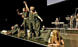 Schwarz gekleidete Jugendliche bei einer Tanzdarbietung auf einer Bühne
