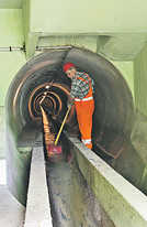 Stadtwerke-Mitarbeiter Heinz Jakobs reinigt den Abwasserstollengang im Bereich Kolbach. Foto: SWT