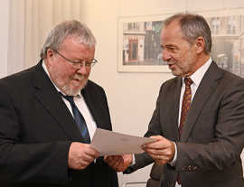 Foto: OB Klaus Jensen (r.) überreicht Dr. Reiner Nolden die Entlassungsurkunde