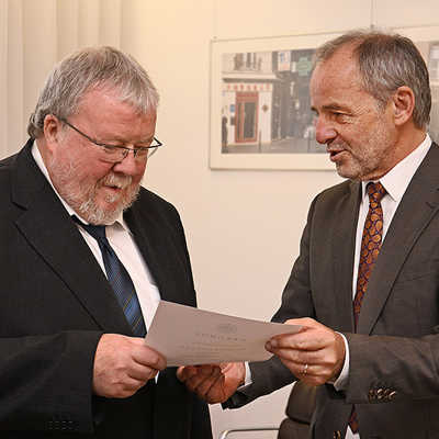 OB Klaus Jensen (r.) überreicht Dr. Reiner Nolden die Entlassungsurkunde und bedankt sich für die fruchtbare Zusammenarbeit im Rahmen der Erinnerungskultur.