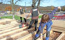 Maik Schuh von einer Holzbaufirma aus Trierweiler (Foto oben, rechts) zieht ein Stromkabel durch die Dachkonstruktion auf einem der neuen Pavillons. Zwei Kollegen verteilen die Sperrholzplatten, auf denen die Bahnen zur Dachabdichtung aufgebracht werden.