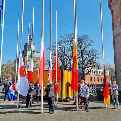 Vertreter der Trierer Partnerschaftsgesellschaften ziehen die neuen Fahnen an den Masten auf dem Konstantinplatz hoch. Sie werden dabei unter anderem unterstützt von OB Wolfram Leibe (links) und vom Kreisbeigeordneten Lutwin Ollinger (vorn, Mitte)