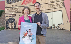 Lisenka Sedlacek und Marco Barbieri stehenvor einer künstlerisch gestalteten Wand und präsentieren das Plakat Junges Theater