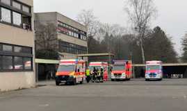 Mehrere Krankentransport- und Rettungswagen stehen vor dem Schulgebäude der Moseltal Realschule Plus.