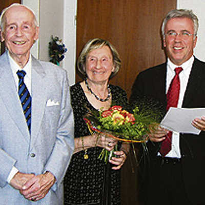 OB Helmut Schröer überreicht Hans und Elisabeth Weske bei seinem Besuch nicht nur die offizielle Gratulationsurkunde, sondern auch einen Blumenstrauß in den Trierer Stadtfarben Rot und Gelb.