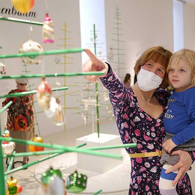 Paula Kolz schaut sich mit Tochter Frieda den historischen Weihnachtsschmuck an, der im Rahmen der neuen Familienausstellung im Stadtmuseum zu sehen ist. Foto: Stadtmuseum