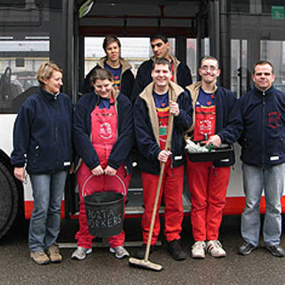 Mit Schrubber und Eimer „bewaffnet“, reinigen die Porta-Workers mit ihren Betreuern Marlene Eiden (l.) und Erich Laudwein (r.) einen Bus. Foto: SWT