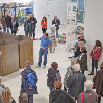 Laas Köhler (Mitte), einer der beiden Kuratoren der aktuellen „Ahoi“-Ausstellung in der EKA-Kunsthalle, stellt den Gästen der Vernissage die stählerne Installation „Hafenmelodie“ von Bernd Bleffert vor.