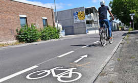 Ein Radfahrer ist unterwegs auf einem Schutzstreifen mit Fahrrad-Piktogramm