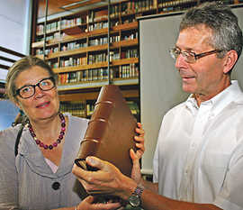 Bürgermeisterin Angelika Birk und Bibliotheksdirektor Michael Embach präsentieren den neuen Einband für den wertvollen Kodex.