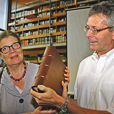 Bürgermeisterin Angelika Birk und Bibliotheksdirektor Michael Embach präsentieren den neuen Einband für den wertvollen Kodex.
