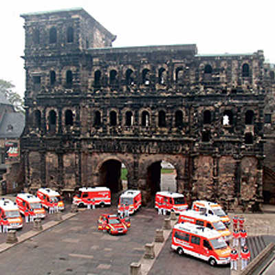 Die aktuelle Fahrzeugflotte des Trierer Rettungsdienstes vor dem Wahrzeichen der Stadt.