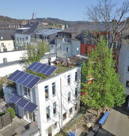 Hinterhaus mit Solarmodulen an der Fassade und auf dem begrünten Dach