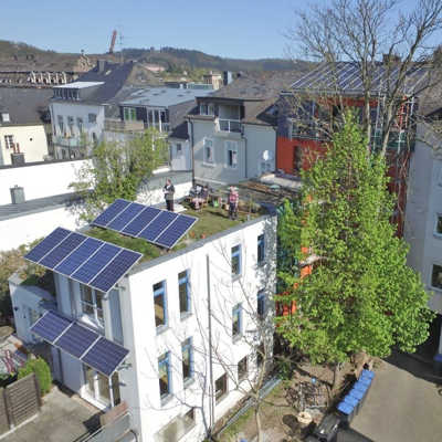 Hinterhaus mit Solarmodulen an der Fassade und auf dem begrünten Dach