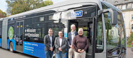 Vier Männer stehen vor einem Gelenkbus der Stadtwerke Trier