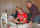 Mike Leinen und Franz Maier vom Wahlbüro-Team (vorn v. l.)  prüfen einen Briefwahlantrag, bevor die Daten im PC erfasst werden.