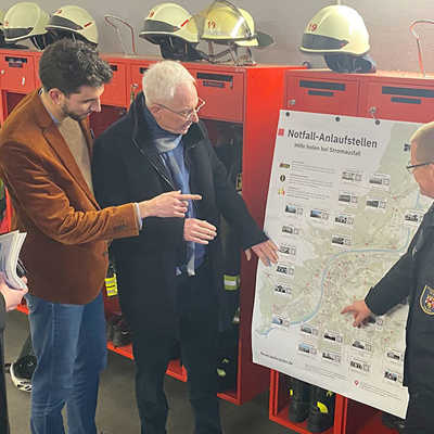Feuerwehrchef Andreas Kirchartz (rechts) und Luka Buntic von der Abteilung Katastrophenschutz der Feuerwehr (2. v. l.), erläutern OB Wolfram Leibe (2. v. r.) und Dezernent Ralf Britten die Karte, auf der die 26 Notfall-Anlaufstellen im Stadtgebiet verzeichnet sind. 