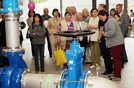 Eine Besuchergruppe steht vor den großen Leitungen im Pumpwerk. Dort gelangt das Wasser zur Aufbereitung in die Membranfilter. Foto: SWT
