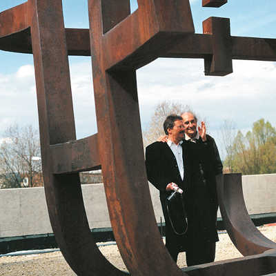 Eduardo Chillida erläutert nach der Aufstellung 1998 seine rund 3,30 Meter hohe Skulptur Bernhard Focht (links), dem Architekten der Europäischen Rechtsakademie. Foto: Dr. Dorothea van der Koelen