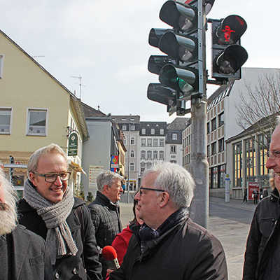 OB Wolfram Leibe, Baudezernent Andreas Ludwig und Zeichner Johannes Kolz (v. r.) freuen sich über den gelungenen Start der neuen Ampelmännchen am Simeonstiftplatz, während Marx selbst (als Wachsfigur) noch etwas skeptisch dreinblickt.